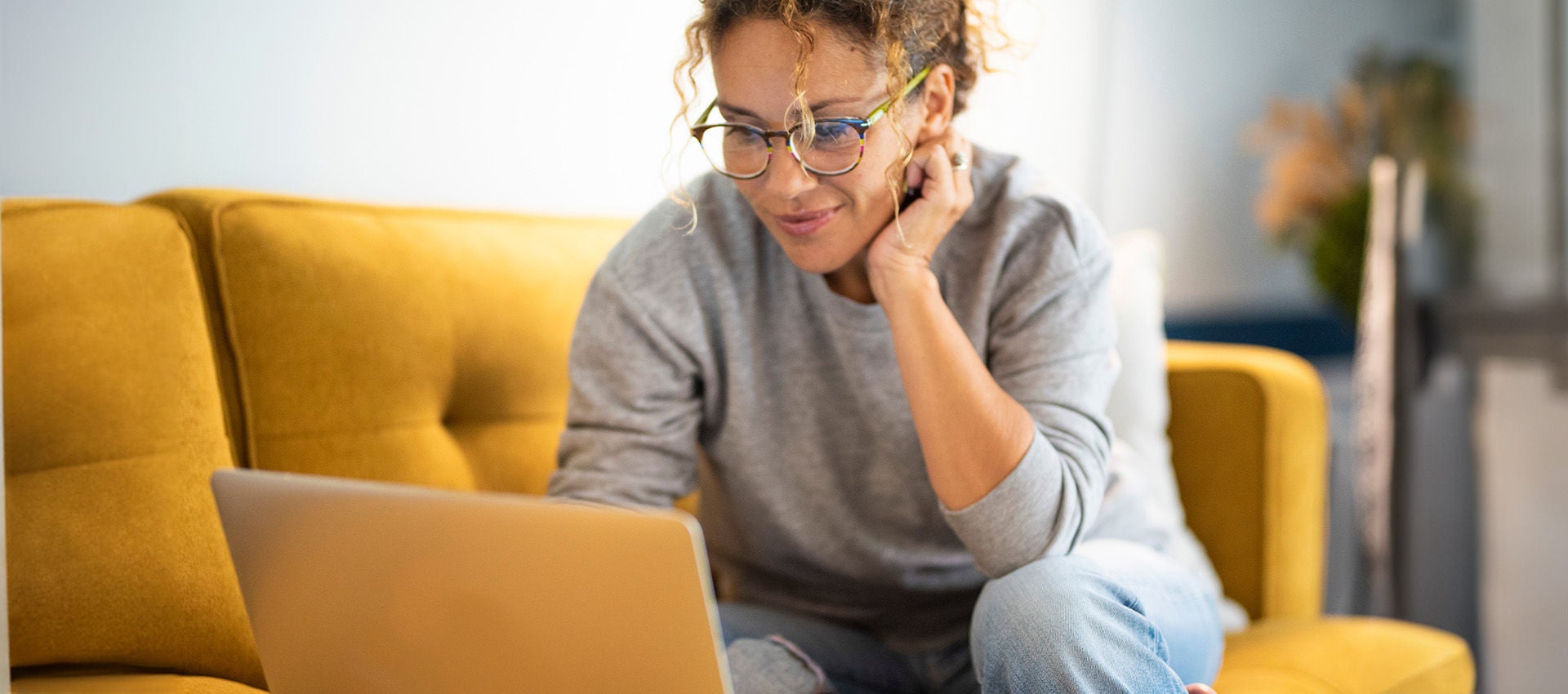 Woman sitting on her couch with her laptop