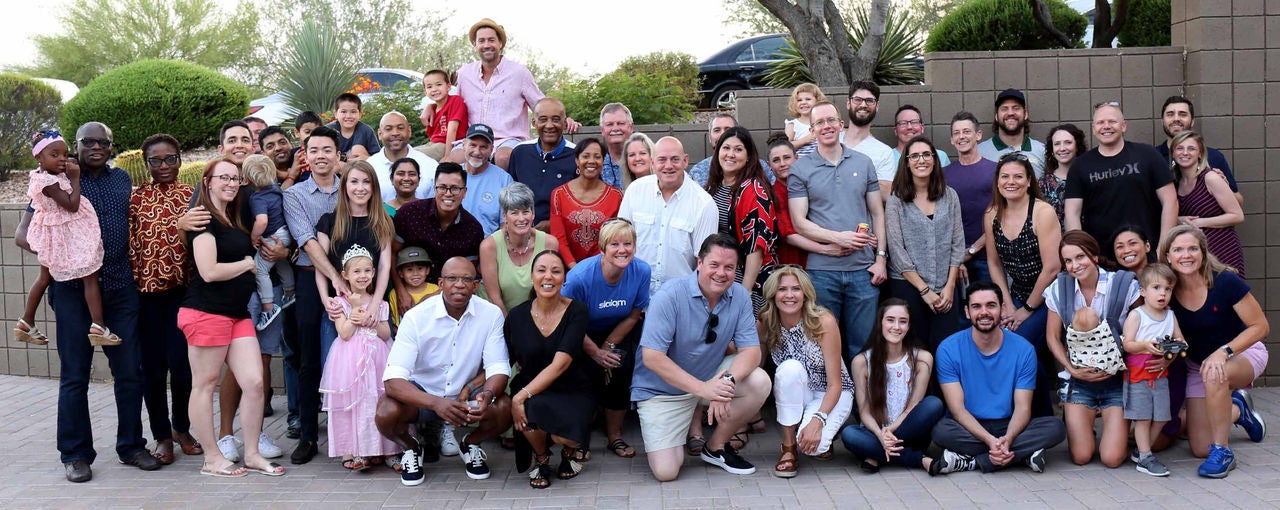 The entire Slalom Phoenix team and their families posing outside a building.