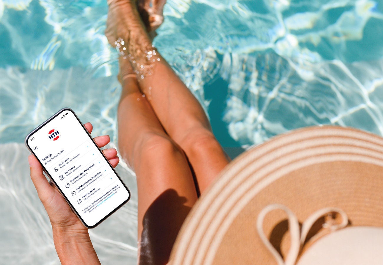 woman looking at phone in pool