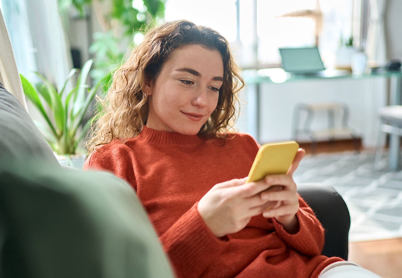 Woman smiling while looking at her phone