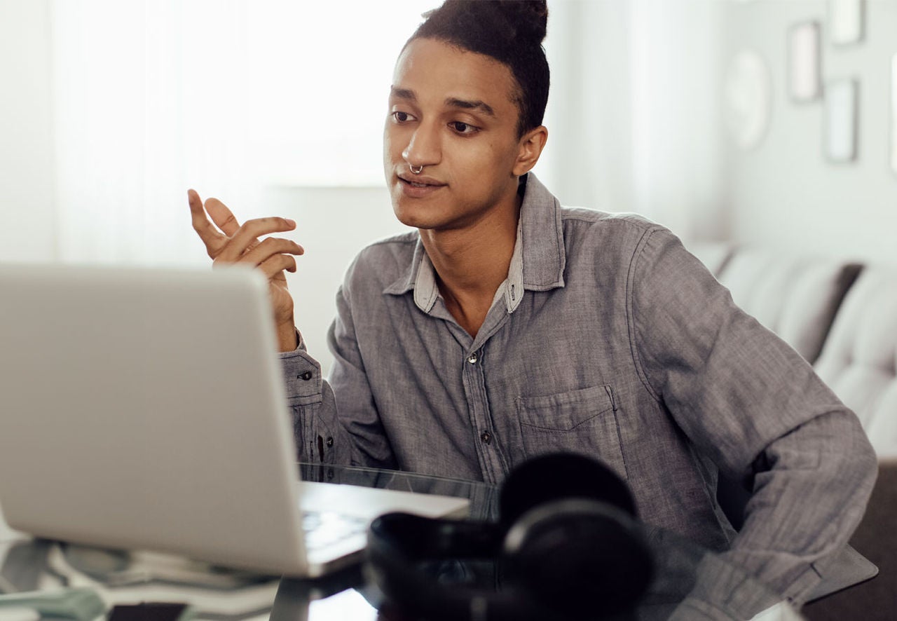 A person interacts with their laptop computer at home.