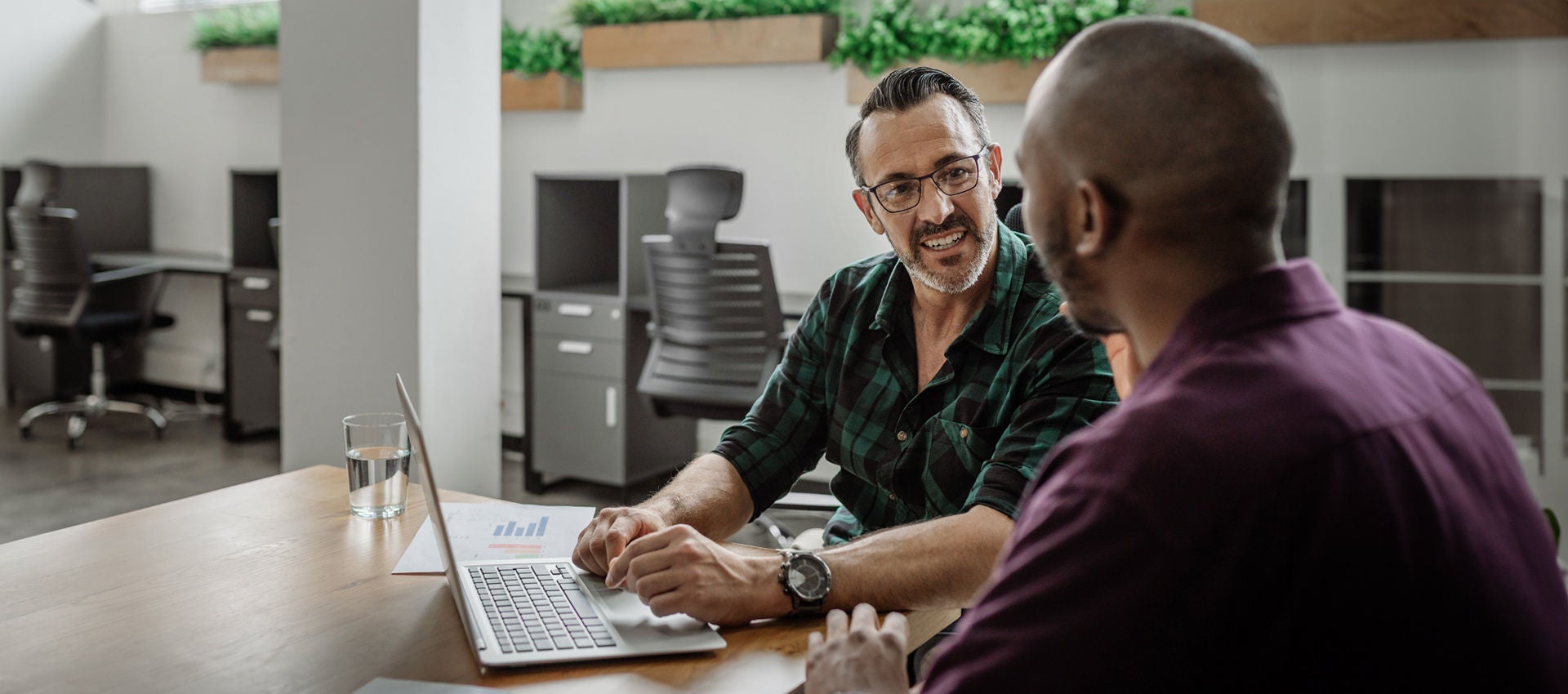 Two people work discuss a solution together at the office.