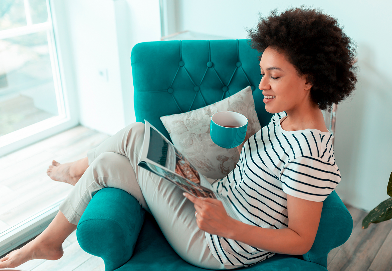 woman reading a magazine and sipping a drink