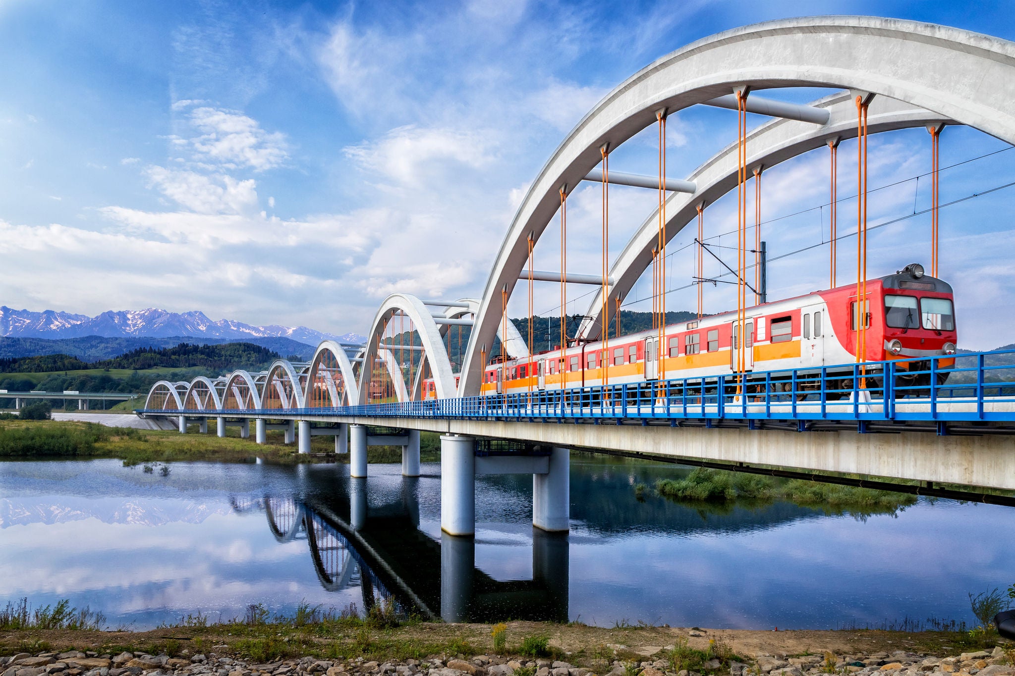 Suburb passenger train drive through the viaduct towards the Tatra Mountains, Poland