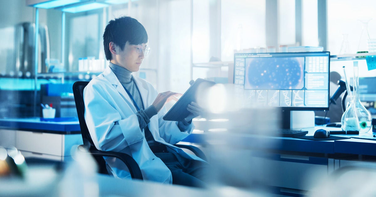 A man works with a tablet in a lab.