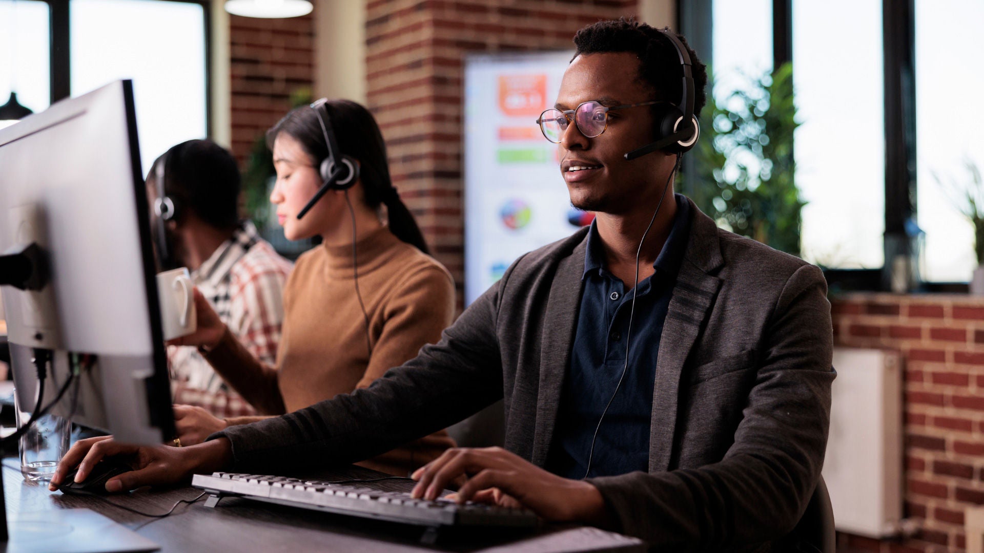 Man working in front of a computer with a headset