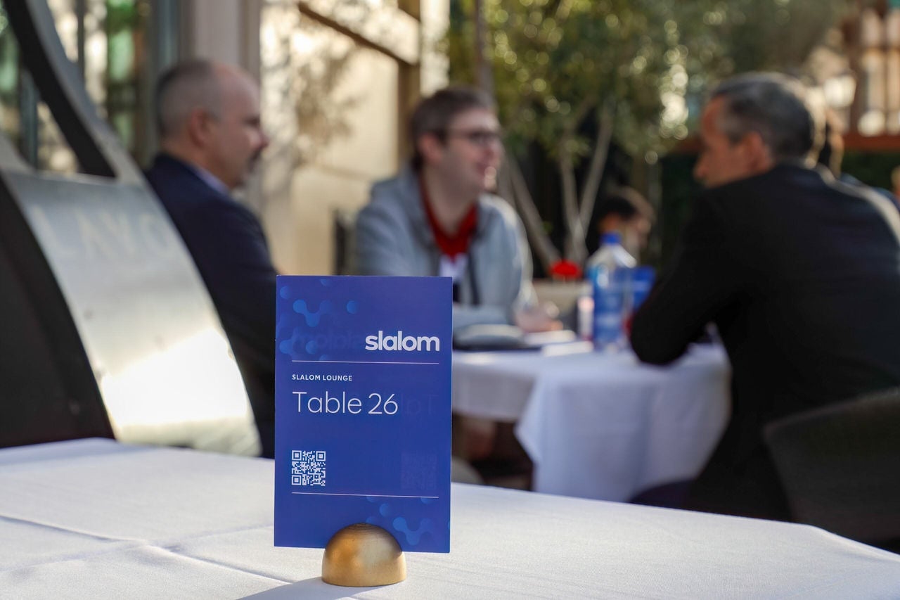 Slalom table at re:Invent three people in background