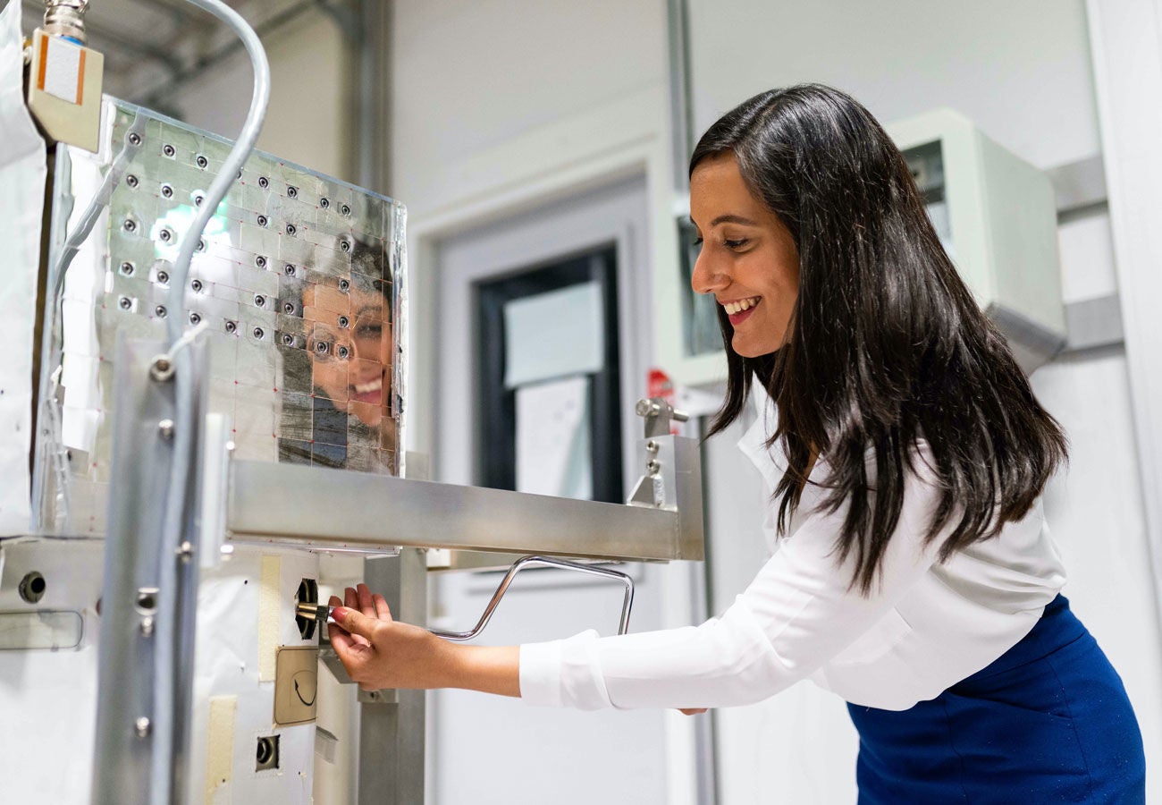 femme souriante et se penchant pour travailler sur une machine