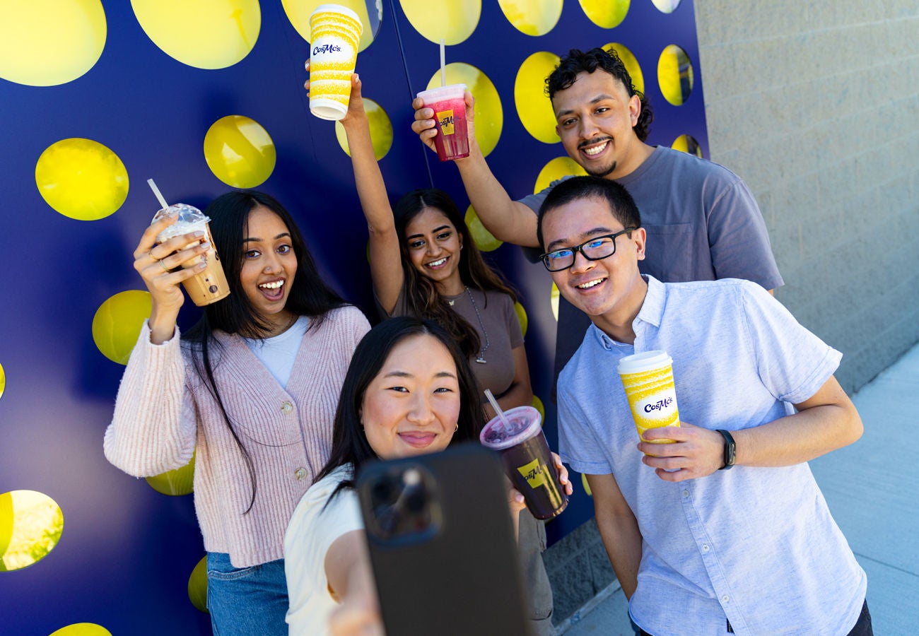 A group of young people are posing for a selfie with their drinks at CosMc's.