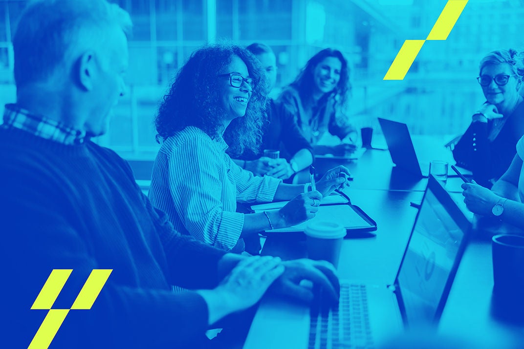 Multi-ethnic business people smiling during a meeting in conference room. Team of professionals having meeting in boardroom.