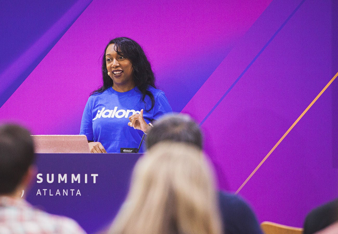 Woman (Kesha Williams) speaking at a podium displaying the words AWS Summit Atlanta