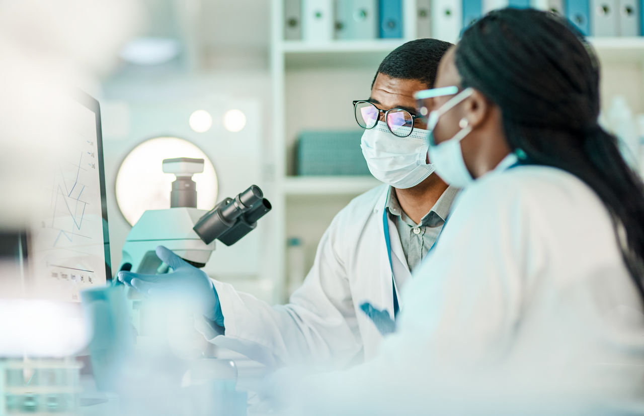 Shot of two scientists working together on a computer in a lab.